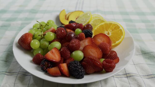 Plate filled with various, colorful fruit - tracking, medium shot