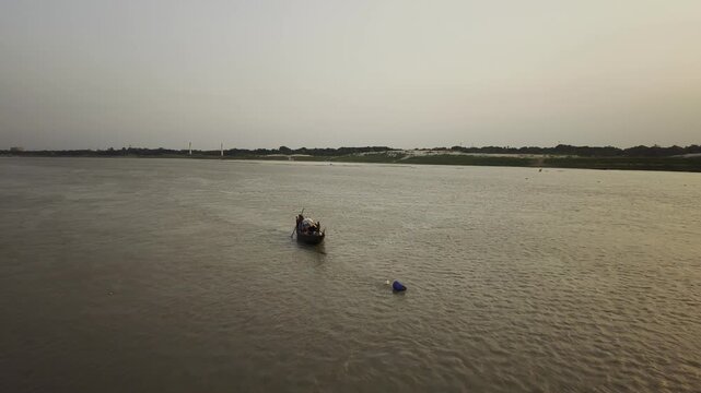 KUSHTIA, BANGLADESH &ndash; JUNE 27, 2026: Drone footage showing a wooden fishing boat with fishermen travelling across the Gorai River, showcasing traditional river transport and fishing culture.