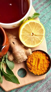 Top view vertical video of healthy ingredients with hot tea lemon ginger turmeric and honey jar.