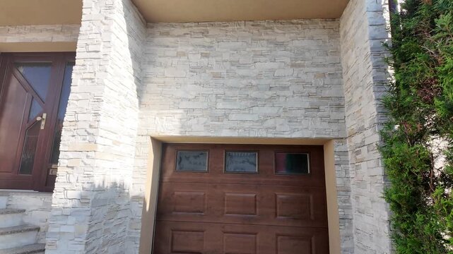 Modern house exterior with stone facade and wooden garage doors