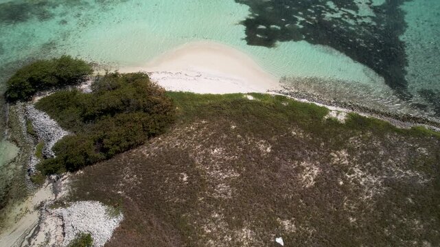 Drone tracking over a remote Caribbean island with queen conch shell mounds, white sand, and turquoise waters in Los Roques, Venezuela.4K Dlog