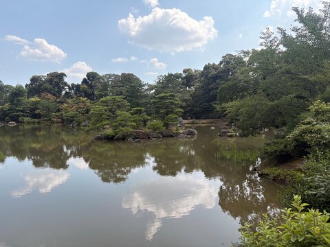 River flowing beneath green mountains and summer clouds