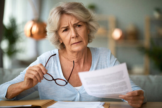 Elderly woman looking confused while reading a document about AI and health data.