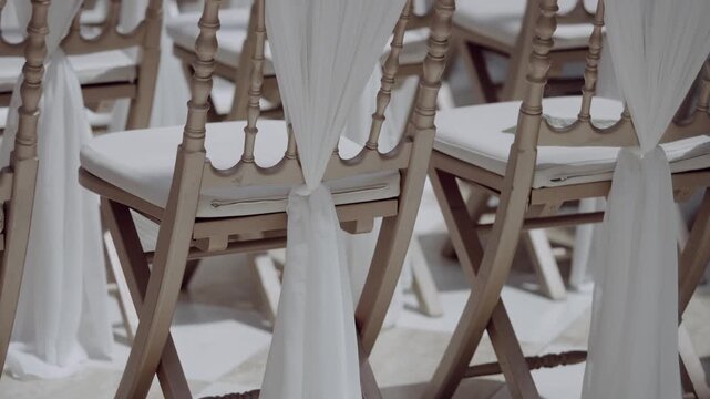 Chiavari chairs with white cushions and fabric sashes at wedding venue