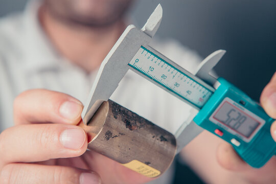 Close up of a man working with a digital caliper on a white background