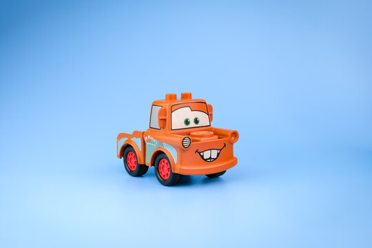 An orange Tow Mater character toy from Disney Pixar Cars is displayed at an angled front view with red wheels and towing equipment on a light blue background on Jul 25, 2026 in Jakarta, Indonesia
