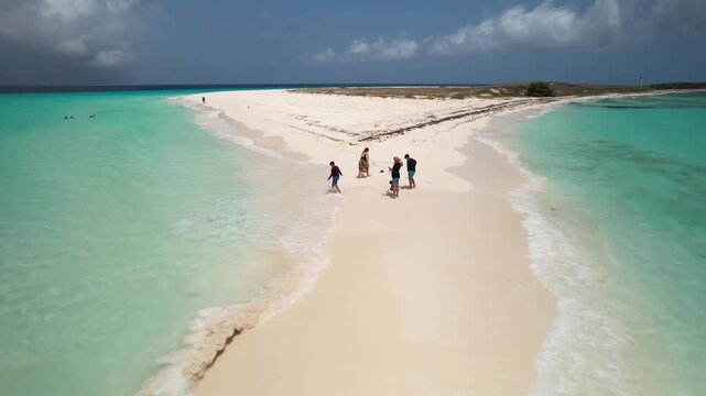 Drone shot People enjoy family time on White sandbar that connects two small islets, allowing to walk "on water" at low tide