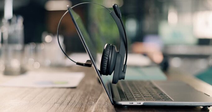 Empty, desk and laptop with headset for customer service communication and contact us at call center. Help, advice and workspace with computer, audio technology and client support with telecom