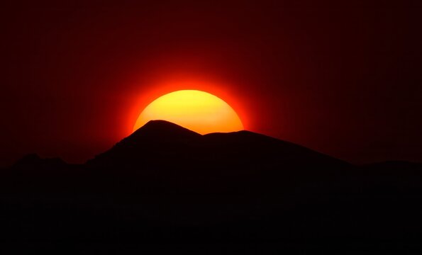 an eerie sunset, with sun spots,  over the colorado rocky mountains through the smoke of the western forest fires , as seen from broomfield