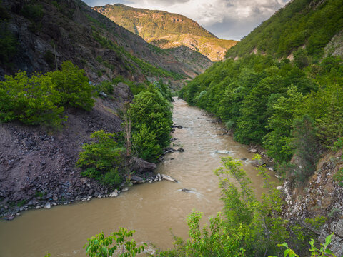 Murky river waters flowing from the mountains and nature in spring.