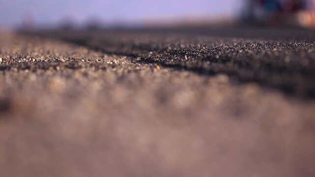 Close up of asphalt while runners pass by