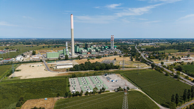 Aerial view of the TTEP Tavazzano thermal power plant and TERNA electrical substation with industrial buildings and surrounding fields in Tavazzano con Villavesco, Lombardy, Italy.