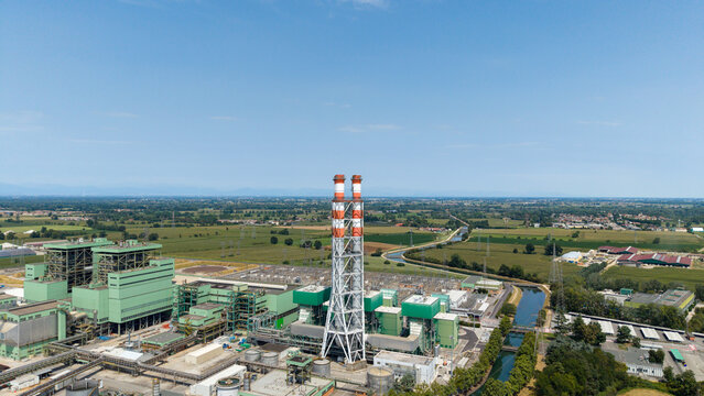 Aerial view of the TTEP Tavazzano thermal power plant and TERNA electrical substation with tall chimneys and industrial buildings in Tavazzano con Villavesco, Lombardy, Italy.