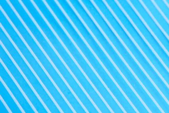 Bright blue textured surface with diagonal parallel white lines creating vibrant modern background.