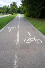 Obraz premium Bicycle path marked with lines and symbols in a green park during daytime