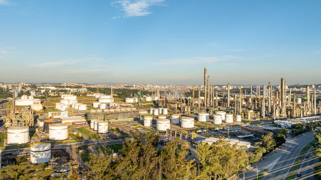 Aerial view of a large petrochemical complex with storage tanks, processing towers, and industrial infrastructure situated in an urban landscape in Santo Andre, State of Sao Paulo, Brazil.