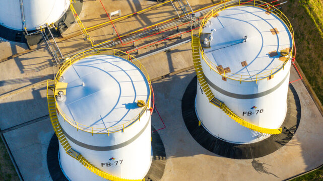 Aerial view of large industrial storage tanks with yellow spiral staircases and connecting pipes at a petrochemical complex in Santo Andre, State of Sao Paulo, Brazil.