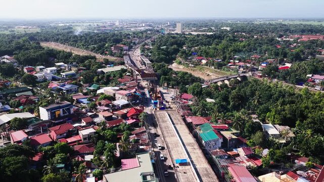 Aerial view of the ongoing construction of the Ungka II flyover project featuring concrete pillars and surrounding residential neighborhoods in Pavia, Western Visayas, Philippines.