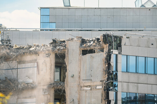Construction site, demolition of reinforced concrete structure, gutting and renovation, hydraulic hammer dismantled building, caterpillar excavator machine 