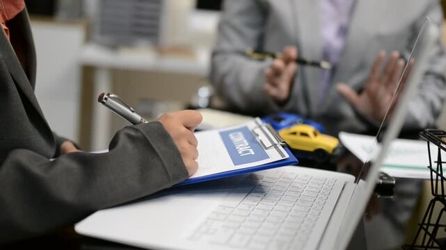 Car sale or rental concept, Closeup Dealership manager signing car insurance document or lease paper contract. Customer with car dealer agent making deal, sign on agreement document contract in office