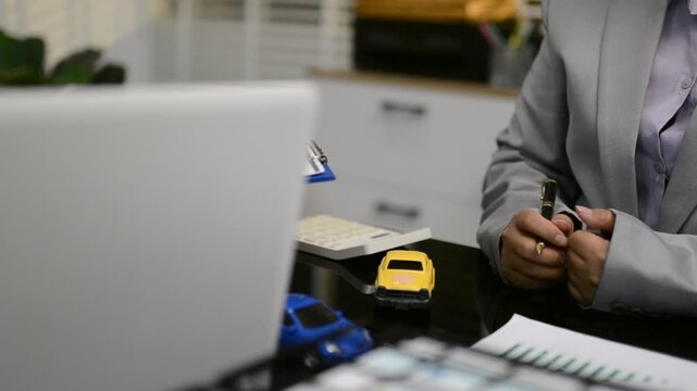 Car sale or rental concept, Closeup Dealership manager signing car insurance document or lease paper contract. Customer with car dealer agent making deal, sign on agreement document contract in office