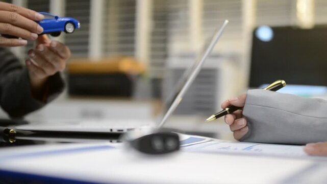 Car sale or rental concept, Closeup Dealership manager signing car insurance document or lease paper contract. Customer with car dealer agent making deal, sign on agreement document contract in office