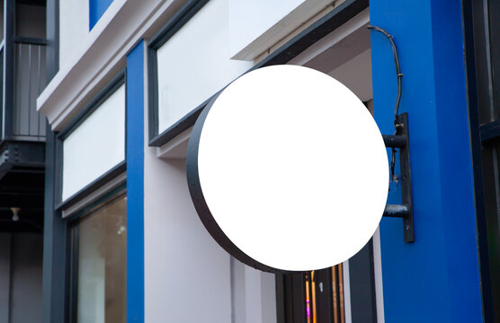 Blank round outdoor sign mockup on blue store building fa&ccedil;ade