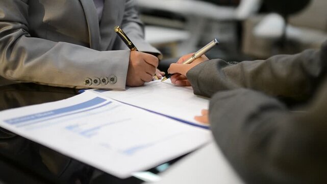 Car sale or rental concept, Closeup Dealership manager signing car insurance document or lease paper contract. Customer with car dealer agent making deal, sign on agreement document contract in office