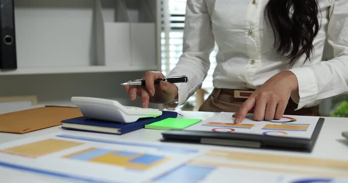 Business professional reviewing financial reports, analyzing business performance, calculating budgets and managing office documents with digital devices for accounting, finance and corporate planning