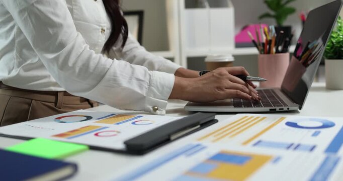 Business professional reviewing financial reports, analyzing business performance, calculating budgets and managing office documents with digital devices for accounting, finance and corporate planning