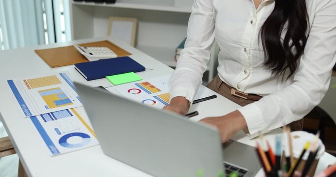 Business professional reviewing financial reports, analyzing business performance, calculating budgets and managing office documents with digital devices for accounting, finance and corporate planning