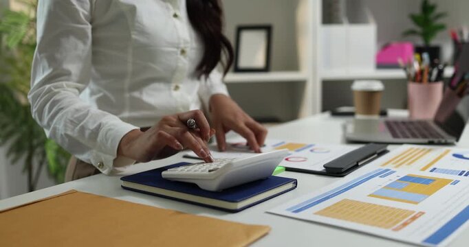 Business professional reviewing financial reports, analyzing business performance, calculating budgets and managing office documents with digital devices for accounting, finance and corporate planning