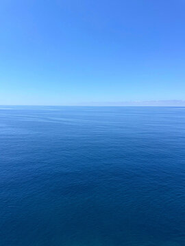 Calm blue sea and clear sunny sky vertical.