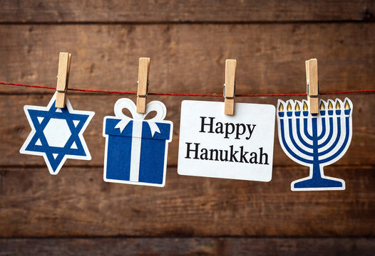 Festive hanukkah decorations with star dreidel gift and menorah on wooden background