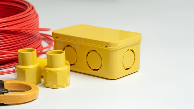 Close-up electrical junction box and red roll electrical wire isolated on white background. Equipment and tools for electrical wiring installation