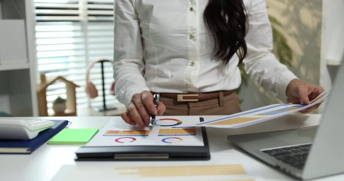 Business professional reviewing financial reports, analyzing business performance, calculating budgets and managing office documents with digital devices for accounting, finance and corporate planning