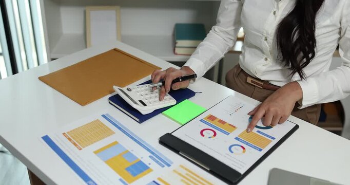 Business professional reviewing financial reports, analyzing business performance, calculating budgets and managing office documents with digital devices for accounting, finance and corporate planning