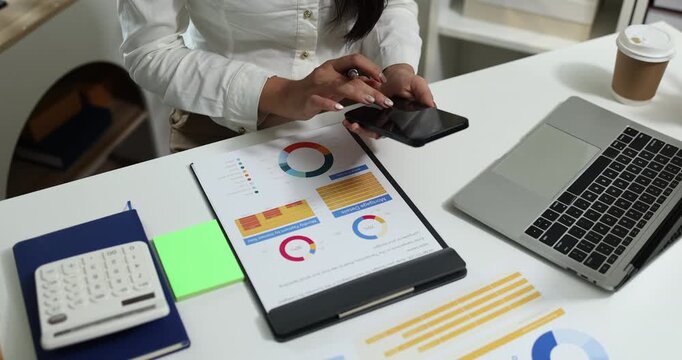 Business professional reviewing financial reports, analyzing business performance, calculating budgets and managing office documents with digital devices for accounting, finance and corporate planning