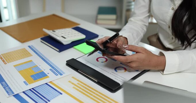 Business professional reviewing financial reports, analyzing business performance, calculating budgets and managing office documents with digital devices for accounting, finance and corporate planning