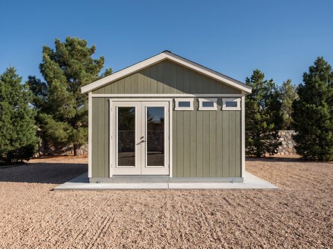 Sage Green Modern Shed with Glass Double Doors Side Windows and Clerestory in Gravel Yard