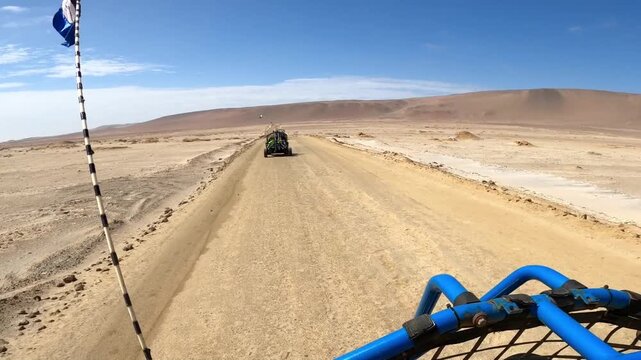 Buggy driving behind another vehicle on remote Paracas desert road