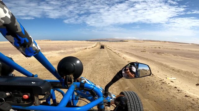 Point of view driving buggy on remote desert dirt road in Paracas