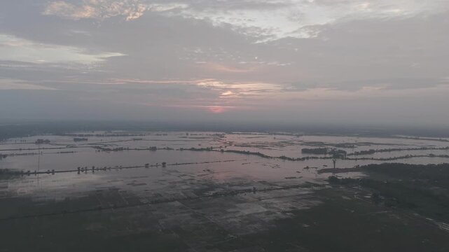 Aerial view of the flooded Gumai Beel landscape during sunset with calm water reflecting the sky in Rangunia Upazila, Chittagong Division, Bangladesh.