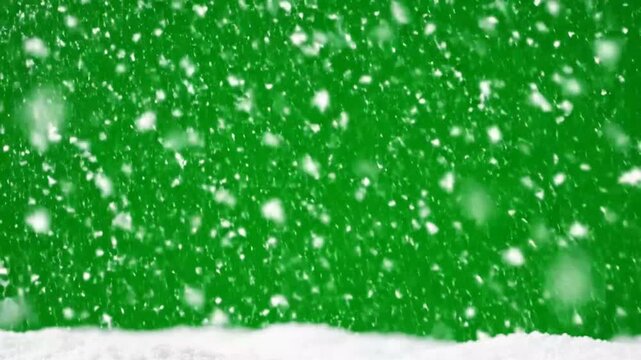 Close-up of snowflakes falling against green background