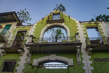Obraz premium Panama City, Panama – January 23, 2023: Abandoned historic building facade with overgrown vegetation 