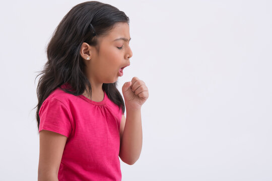Portrait of a young girl coughing due to air pollution. (Children) 