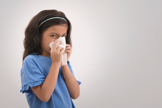 Young girl wiping her nose with a handkerchief. (Children) 