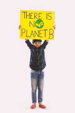 Young boy holding a placard in hand with a message to save mother earth. (Children) 