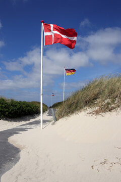 d&auml;nische und deutsche flagge wehen am strand