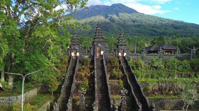 Drone pull-away from Pura Penataran Agung Nangka Balinese Hindu temple revealing Mt. Agung, Bali, Indonesia